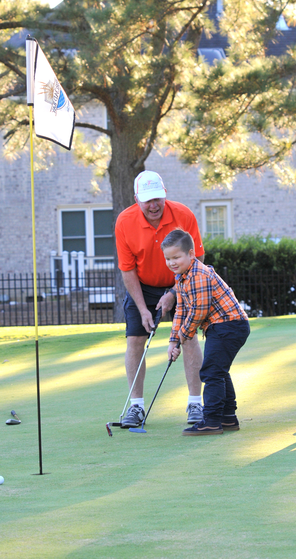 CAPT George E. Sauer III, USN (Ret.), Chartway board chairman, cheered on We Promise hero, Gideon, as he sunk a putt during the 21st Annual Charity Golf Classic.