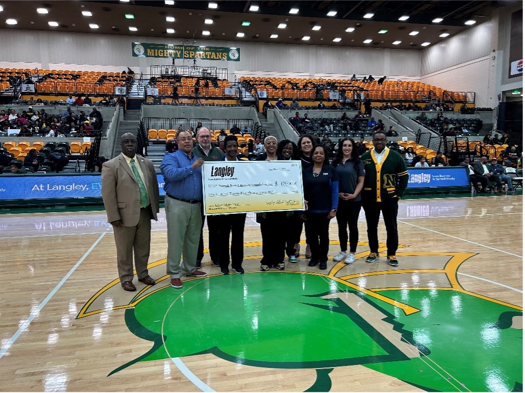 Audrey Douglas-Cooke, vice chair of the Langley Board and a professor at Norfolk State University, left, is shown next to NSU President Javaune Adams-Gaston, right, holding a $125,000 scholarship check from Langley Federal Credit Union presented on March 8. (courtesy photo)